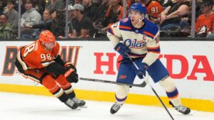 Edmonton Oilers center Connor McDavid, right, tries to pass while under pressure from Anaheim Ducks defenseman Pavel Mintyukov during the first period of an NHL hockey game Wednesday, Oct. 7, 2026, in Anaheim, Calif. (AP Photo/Mark J. Terrill)