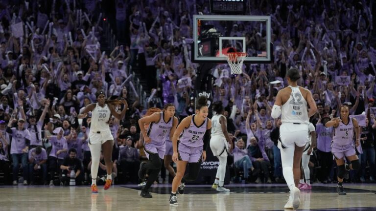 Fans cheer as Golden State Valkyries guard Veronica Burton, bottom middle, reacts after making a 3-point basket during the second half of Game 2 of the WNBA basketball semifinals against the Las Vegas Aces, Wednesday, Oct. 7, 2026, in San Francisco. (AP Photo/Jeff Chiu)