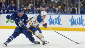 Toronto Maple Leafs defenceman Morgan Rielly (44) battles with Buffalo Sabres forward Konsta Helenius (94) during first period NHL hockey action in Toronto on Thursday, Oct. 15, 2026. THE CANADIAN PRESS/Nathan Denette