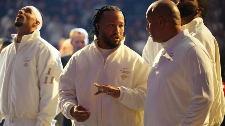 New York Knicks guard Jalen Brunson, center, shows his ring to his father Rick Brunson before an NBA game between the New York Knicks and the Philadelphia 76ers Tuesday, Oct. 20, 2026, in New York. (Frank Franklin II/AP)