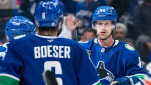 Vancouver Canucks' Elias Pettersson (40) celebrates with teammates Jake DeBrusk (74) and Brock Boeser (6) after scoring a goal as Oilers' Alex Formenton (26) skates past during third period NHL hockey action in Vancouver, B.C., on Thursday, Oct. 1, 2026. (Rich Lam/CP)