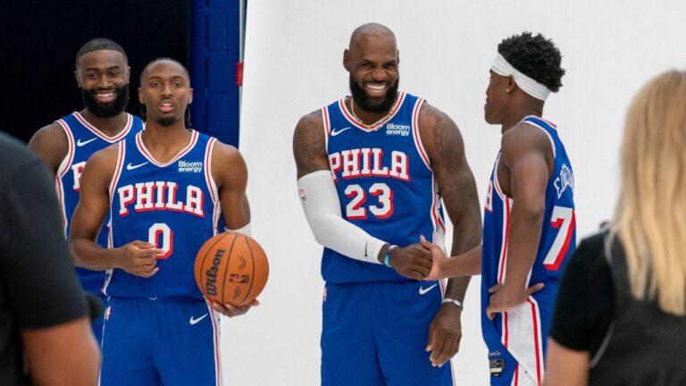 Philadelphia 76ers' LeBron James, center right, greats VJ Edgecombe, right, as they get ready for a group photos with Tyrese Maxey, center left, and Jaylen Brown, left, during the NBA basketball team's media day, Monday, Sept. 28, 2026, in Camden, N.J.. (AP Photo/Chris Szagola)