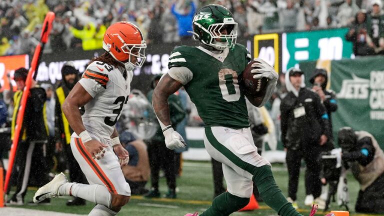 New York Jets running back Braelon Allen (0) scores a touchdown ahead of Cleveland Browns safety Ronnie Hickman (33) during the second half of an NFL football game, Sunday, Oct. 11, 2026, in East Rutherford, N.J. (AP Photo/Seth Wenig)
