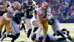 San Francisco 49ers running back Christian McCaffrey (23) runs for a touchdown against the Seattle Seahawks during the first half of an NFL football game Sunday, Oct. 11, 2026, in Seattle. (AP Photo/Stephen Brashear)