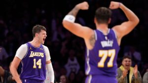 Los Angeles Lakers center Walker Kessler, left, celebrates along with guard Luka Doncic after scoring during the second half of an NBA basketball game against the LA Clippers, Friday, Oct. 23, 2026, in Los Angeles. (AP Photo/Mark J. Terrill)