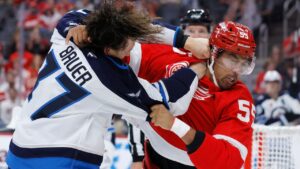 Winnipeg Jets defenceman Tyrel Bauer, left, and Detroit Red Wings right winger Keegan Kolesar fight during the first period of an NHL game Sunday, Oct. 4, 2026, in Detroit. (Duane Burleson/AP)