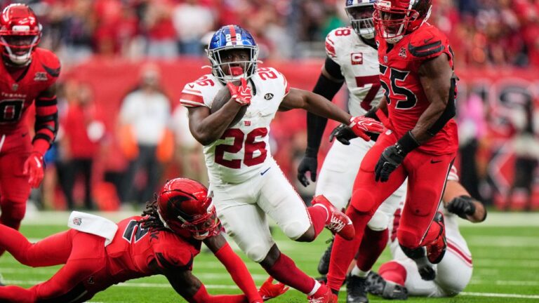 New York Giants running back Devin Singletary (26) breaks away from defenders to score the game-winning touchdown in overtime of an NFL football game. (Gerald Herbert/AP)