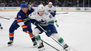 New York Islanders' Emil Heineman (51) fights for control of the puck with Vancouver Canucks' Liam Ohgren (92) during the first period of an NHL hockey game Tuesday, Oct. 13, 2026, in Elmont, N.Y. (Frank Franklin II/AP)