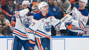 Edmonton Oilers' Connor McDavid (97) is congratulated by teammate Mattias Ekholm (14) after scoring a goal against the Vancouver Canucks during second period NHL hockey action in Vancouver, B.C., on Thursday, Oct. 1, 2026. (Rich Lam/CP)