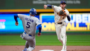 Milwaukee Brewers second baseman Brice Turang (2) forces out Los Angeles Dodgers first baseman Freddie Freeman (5) as he turns a double play on Dodgers' Will Smith during Game 1 of baseball's National League Championship Series between the Milwaukee Brewers and the Los Angeles Dodgers, Sunday, Oct. 11, 2026, in Milwaukee. (Ashley Landis/AP)