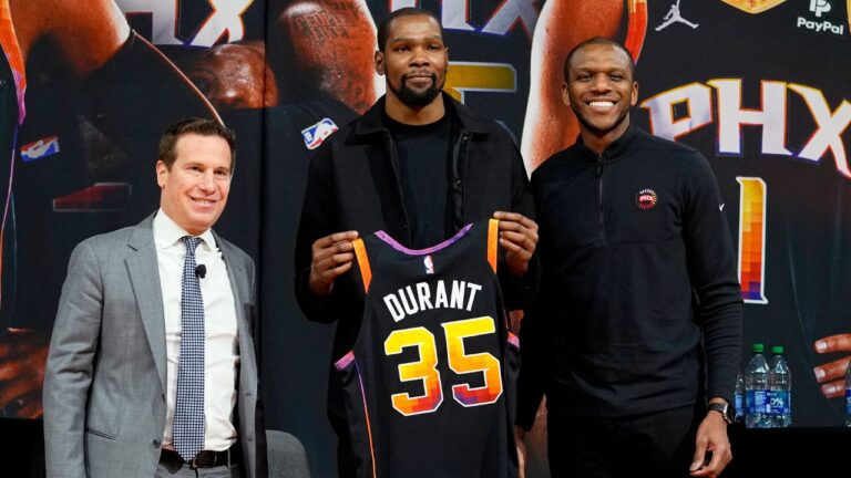 Former Phoenix Suns forward Kevin Durant, centre, holds his jersey after being introduced during an NBA basketball team availability by owner Mat Ishbia, left, and general manager James Jones, Thursday, Feb. 16, 2023, in Phoenix. (Matt York/AP Photo)