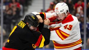 Vancouver Canucks' Luke Schenn (2) and Calgary Flames' Adam Klapka (43) fight during the first period of an NHL hockey game, in Vancouver, on Saturday, Oct. 3, 2026. (Jacob Mallari/THE CANADIAN PRESS)