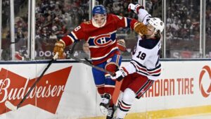 Winnipeg Jets' Dawson Mercer (19) is checked by Montreal Canadiens' Lane Hutson (48) during first period NHL Heritage Classic action in Winnipeg on Sunday, Oct. 25, 2026. (Fred Greenslade/THE CANADIAN PRESS)
