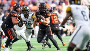 B.C. Lions' Zander Horvath (centre) runs past Hamilton Tiger-Cats Charbel Dabire (second left) during second half of CFL football action in Vancouver on Saturday, August 8, 2026. (Rich Lam/CP)