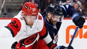 Winnipeg Jets' Dylan DeMelo (2) defends against Carolina Hurricanes' Nikolaj Ehlers (27) during first period NHL hockey action in Winnipeg, Saturday, Oct. 17, 2026. (John Woods/THE CANADIAN PRESS)