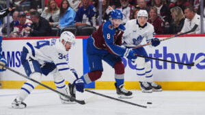 Colorado Avalanche defenceman Cale Makar, centre, pursues the puck with Toronto Maple Leafs center Auston Matthews, left, and right wing Easton Cowan, right, in the second period of an NHL hockey game Saturday, Oct. 10, 2026, in Denver. (David Zalubowski/AP)