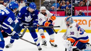New York Islanders goaltender Ilya Sorokin (30) makes a save as Toronto Maple Leafs' Auston Matthews (34) and Islanders' Kyle Palmieri (21) battle for the rebound during second period NHL hockey action. (Frank Gunn/THE CANADIAN PRESS)