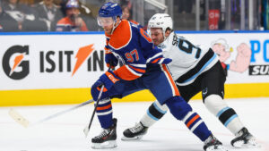 Edmonton Oilers' Connor McDavid (97) protects the puck from Utah Mammoth's Mikhail Sergachev (98) during second period NHL hockey action in Edmonton on Thursday, Oct. 15, 2026. (Codie McLachlan/CP)