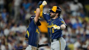Milwaukee Brewers center fielder Garrett Mitchell celebrates his solo home run with Cooper Pratt during the sixth inning of Game 4 of baseball's National League Championship Series between the Milwaukee Brewers and the Los Angeles Dodgers, Thursday, Oct. 15, 2026, in Los Angeles. (Ashley Landis/AP)