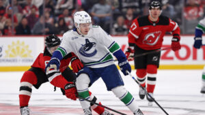 Vancouver Canucks right wing Jonathan Lekkerimaki (88) has the puck knocked away by New Jersey Devils right wing Arseny Gritsyuk during the first period of an NHL hockey game Saturday, Oct. 10, 2026, in Newark, N.J. (Adam Hunger/AP)