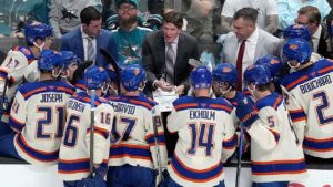 Edmonton Oilers head coach Mike Babcock, center, talks with his players during a timeout in the third period of an NHL hockey game. (Tony Avelar/AP)
