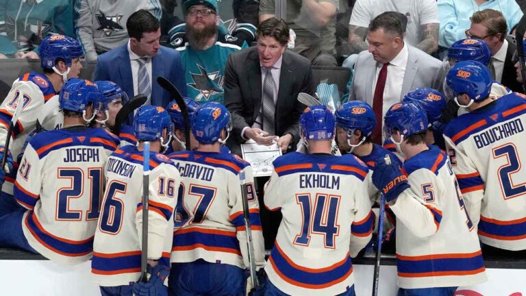 Edmonton Oilers head coach Mike Babcock, center, talks with his players during a timeout in the third period of an NHL hockey game. (Tony Avelar/AP)