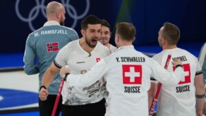 Switzerland's Benoit Schwarz-van Berkel, Yannick Schwaller, Sven Michel and Pablo Lachat-Couchepin celebrate winning a men's curling bronze medal match between Norway and Switzerland, at the 2026 Winter Olympics, in Cortina d'Ampezzo, Italy, Friday, Feb. 20, 2026. (Misper Apawu/AP)