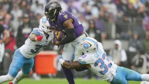 Baltimore Ravens running back Derrick Henry (22) runs the ball against Tennessee Titans safety Amani Hooker (37) and linebacker Cedric Gray (33) during the second half of an NFL football game in Baltimore, Sunday, Oct. 4, 2026. (Stephanie Scarbrough/AP)