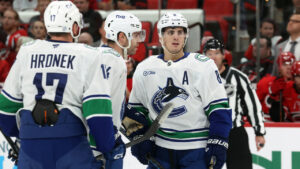 Vancouver Canucks' Zeev Buium (8) is congratulated by teammates after his goal during the third period of an NHL hockey game against the Carolina Hurricanes in Raleigh, N.C., Thursday, Oct. 8, 2026. (Karl DeBlaker/AP)
